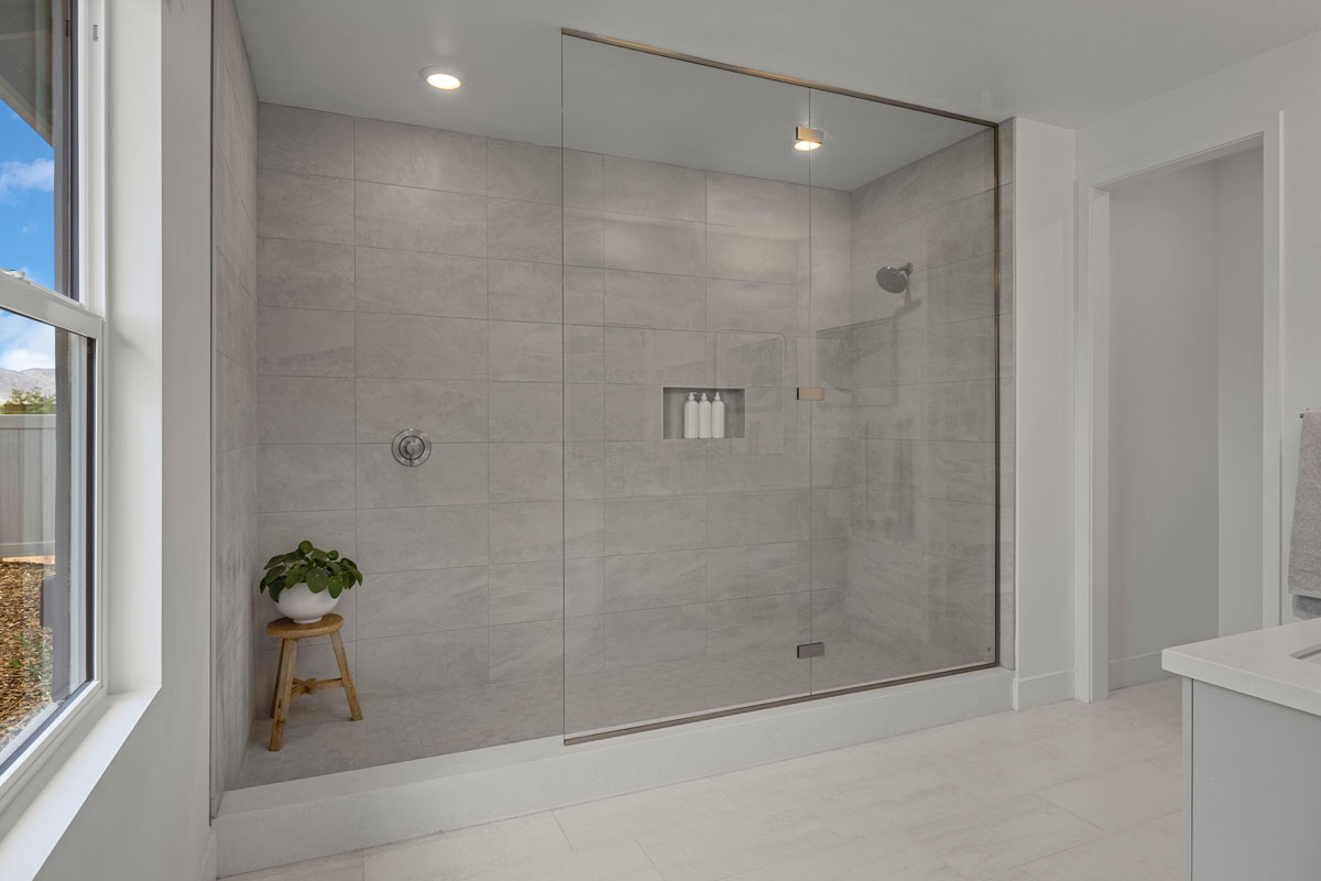 Extended walk-in shower with frameless glass enclosure at primary bath