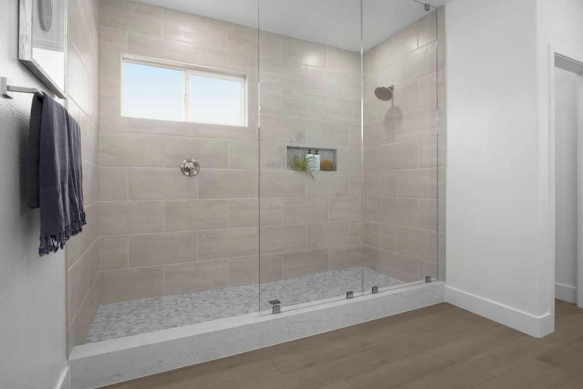 Extended walk-in shower with frameless glass enclosure at primary bath