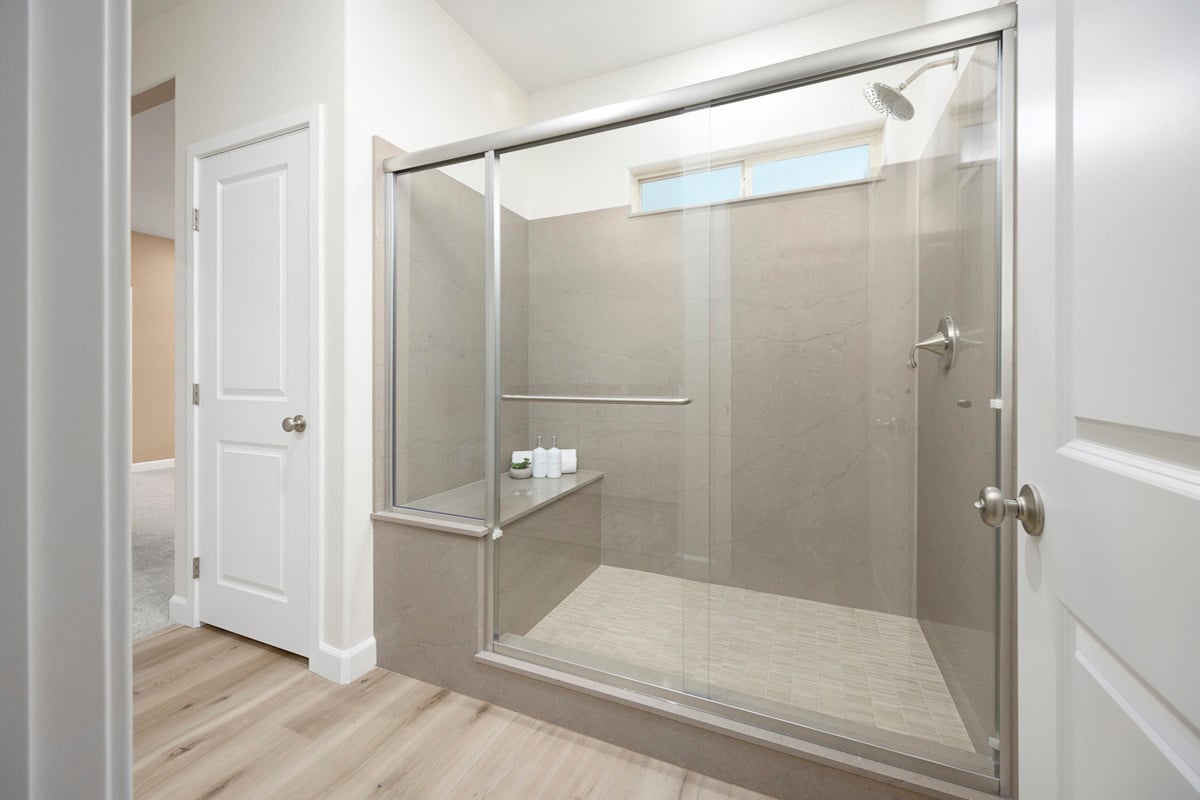 Enlarged walk-in shower with seat at primary bath